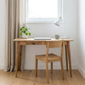 Scandi oak-finish desk with laptop and lamp under a window
