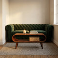 Nordic chestnut coffee table with open shelf in front of a green velvet sofa